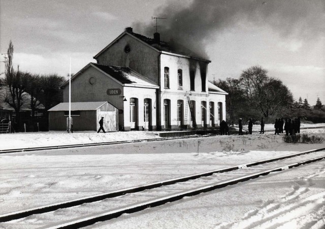 station Uden bron: Ad Verhoeven. <br/>Lang geleden rond 1969 fietste ik over de Prior van Milstraat en keek ik in het voorbijgaan de Stationstraat in. Ik zag dikke rookwolken boven het station. Toevallig had mijn fototoestel bij me dus heb ik er een kiekje van gemaakt. Nu, bij een speurtochtje naar de geschiedenis van Peerke Verschiet en de Ujese Zwarte, kwam ik toevallig weer langs het station, maar nu via jouw website. Het viel mij op dat de overgangssituatie van zadeldak naar plat dak ontbreekt in jouw verzameling. Na enig zoekwerk in de bekende oude schoenendozen vond ik een afdrukje dat ik hierbij toestuur.