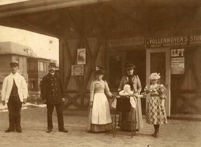 station Utrecht Biltstraat Kopse kant van een van de perrongebouwtjes. <p>De familie Dörr op station. Anne Christine Virginie Dörr-Thoman met dochters Alida (r) en Anne in kinderwagen. Het echtpaar Dörr-Thoman heeft 3 dochters gehad. Anne Gerardine Dörr, die 28-03-1881 werd geboren, overleed in Utrecht op 02-03-1888. Het verhaal gaat dat zij gevallen was door een bovenlicht.
<P>
Het grote meisje op de foto is Alida Dörr, geboren in Utrecht op 14-05-1883. Zij trouwde in Utrecht op 23-07-1907 met haar volle neef Henri Jacques Thoman.
<p>
De baby in de kinderwagen is Anne Dörr die geboren werd in Utrecht op 28-01-1893 en dus net als haar eerder overleden zusje heette. De foto is gemaakt op 9 juli 1893, dit staat achter op de foto vermeld.
<p>
Origineel in bezit van Hermine Dekkers, nakomelinge van de familie.